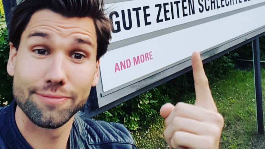 Alexander Keen steht in Babelsberg vor einem GZSZ-Schild