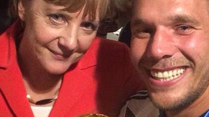Lukas Podolski und Angela Merkel