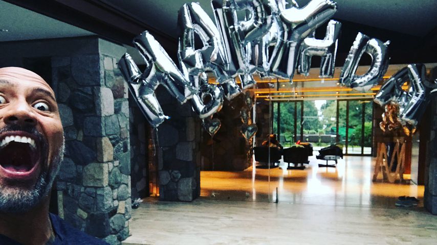 Dwayne "The Rock" Johnson albern vor einer "Happy Birthday"-Girlande