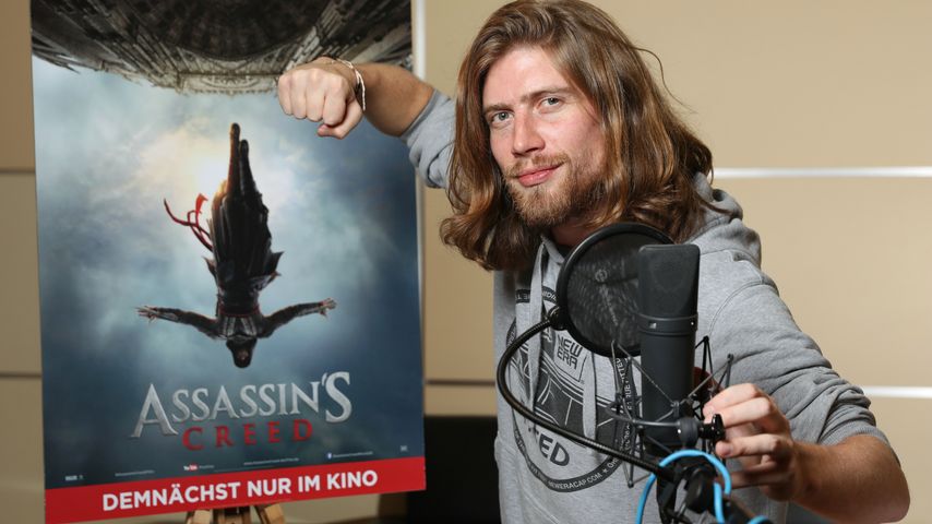 Sarazar vor dem Filmplakat von "Assassin's Creed"