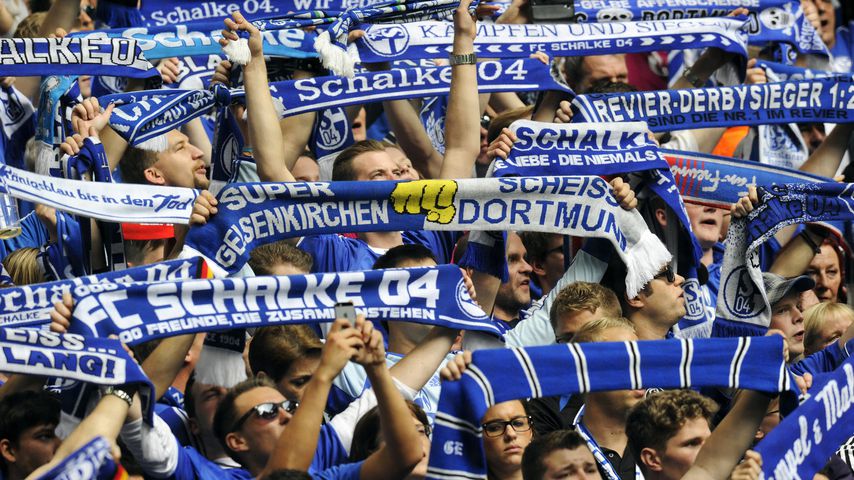 Schalke Fans in der Nordkurve mit Schals