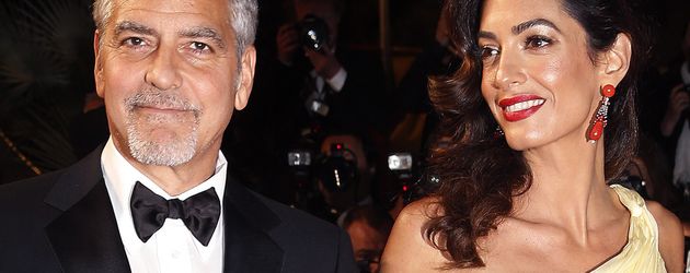 George Clooney und seine Frau Amal auf dem roten Teppich in Cannes 2016 George Clooney und seine Frau Amal auf dem roten Teppich in Cannes 2016