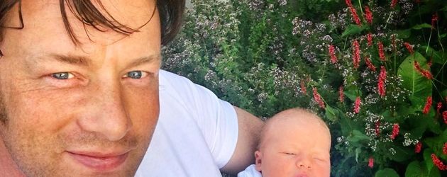 Jamie Oliver und sein neugeborener Sohn im Garten Jamie Oliver und sein neugeborener Sohn im Garten