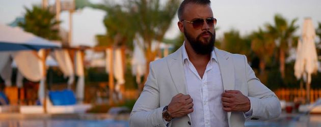 Kollegah vor einem Swimming Pool unter Palmen Kollegah vor einem Swimming Pool unter Palmen